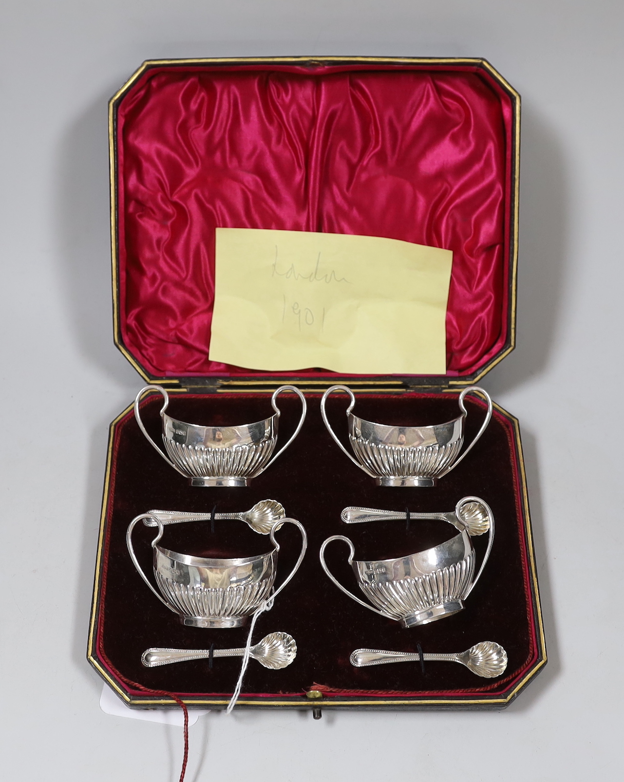 A cased set of four Edwardian demi-fluted silver two handled salts and four spoons, James Dixon & Sons, Sheffield, 1908.